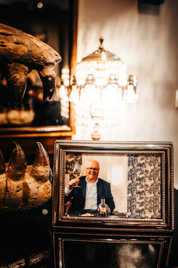 Ingelijste foto van oprichter Fred Rademaker, het glas geheven